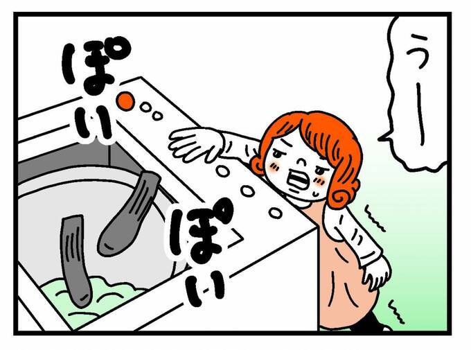 洗濯機に靴下を入れる子ども