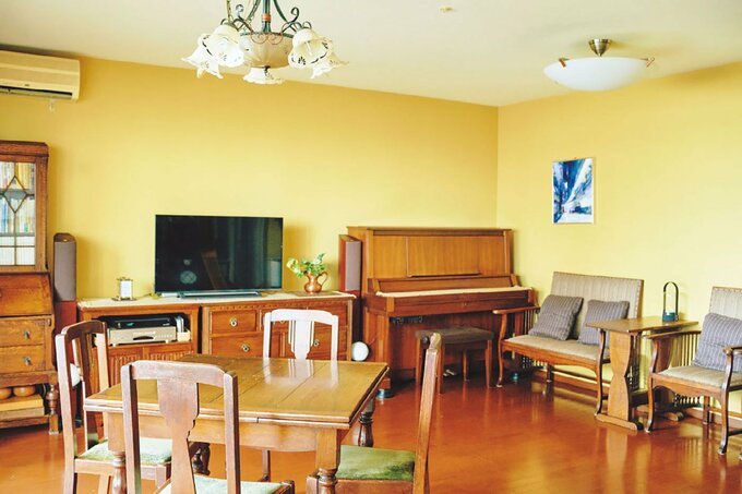 黄色い壁紙の広いリビング