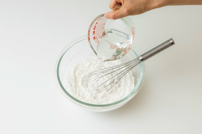 ぬるま湯を加えてパンの材料を混ぜる様子