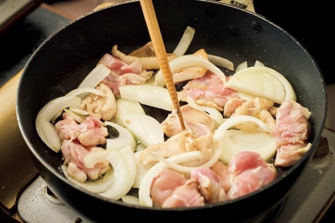 肉とタマネギをフライパンで炒める