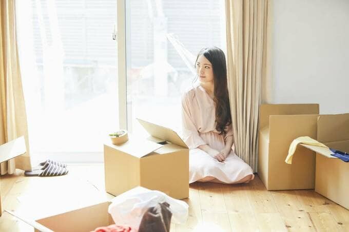 部屋に段ボールと女性