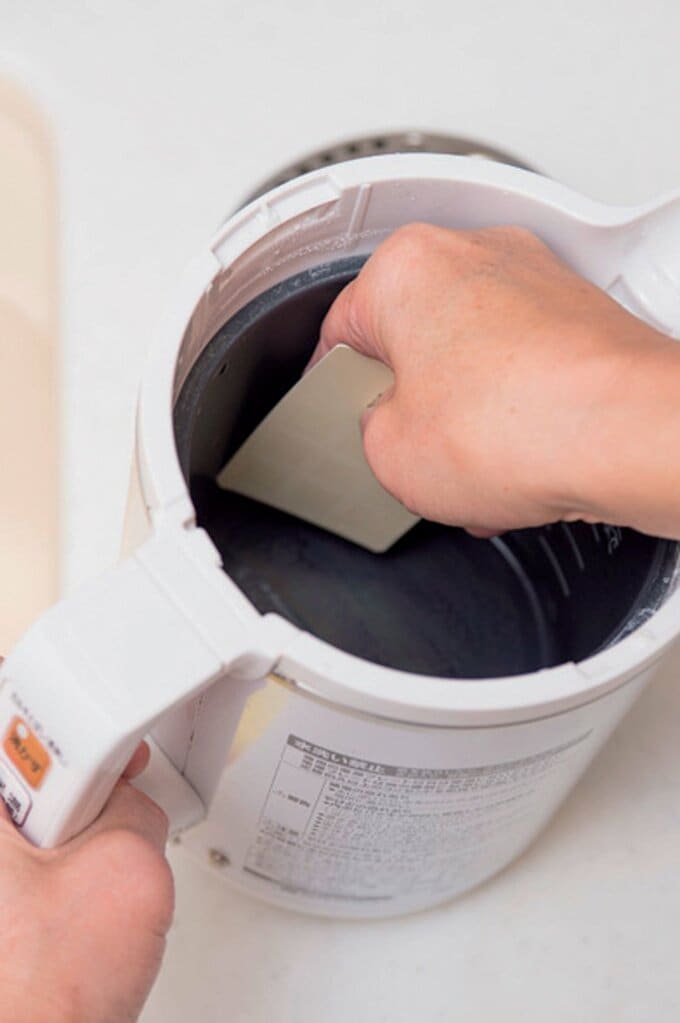 湯を捨て、こびりついた水アカをカードで削り落とす