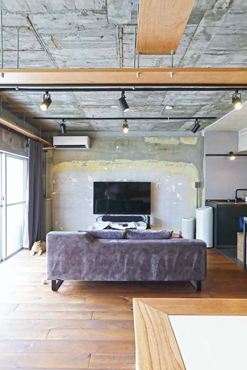 躯体現しにした古い団地特有の壁面が味わい深いリビング