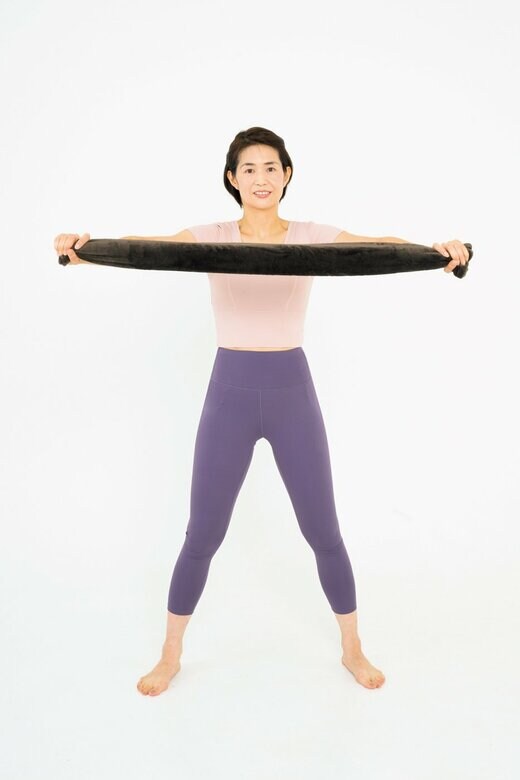 バスタオルを両手に持つ女性