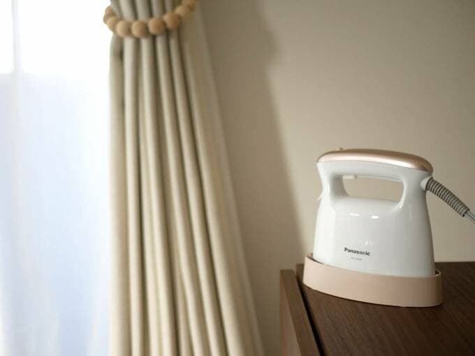 カーテンのそばにスチームアイロンが置いてある様子