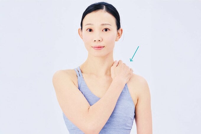 肩に手を当てる女性