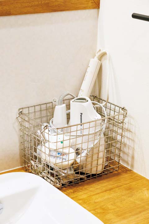 スチールのカゴにザクッと収納したドライヤー