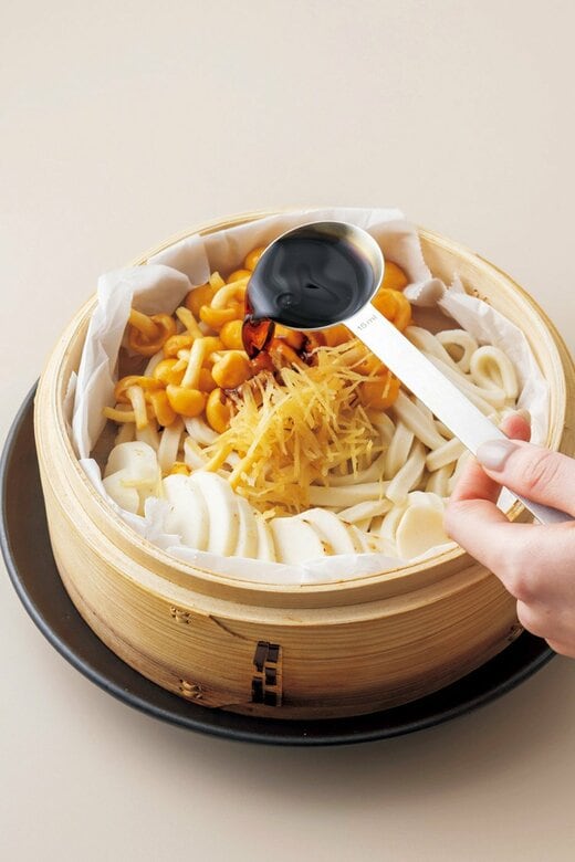 うどんに調味料を回しかける