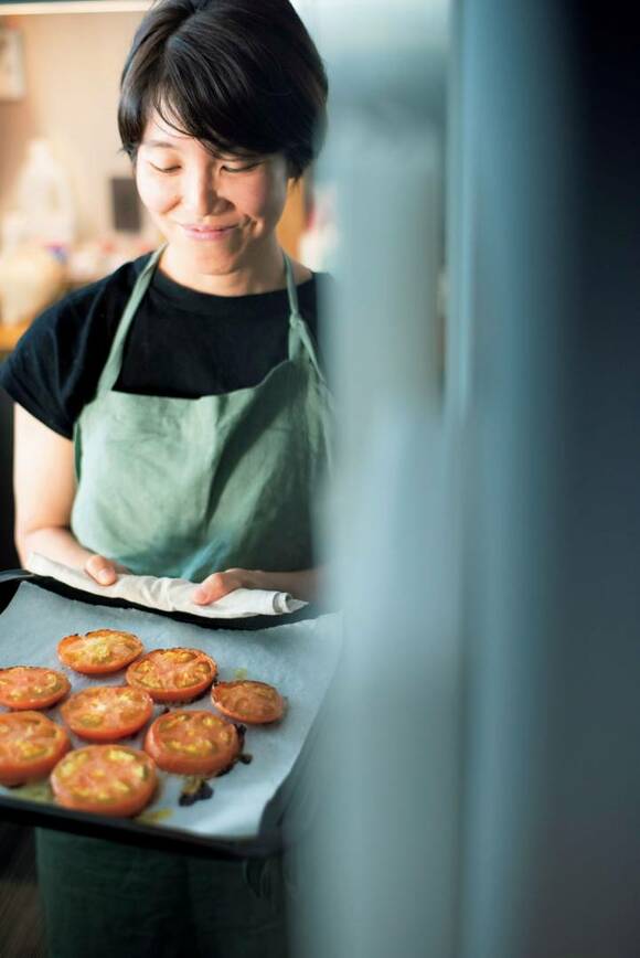 女性トマトをオーブンに