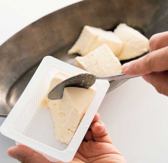 豆腐をスプーンですくっている様子