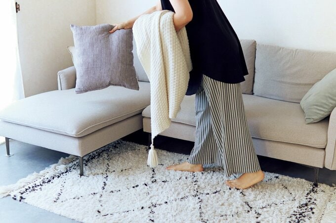 ソファの上を整理する女性