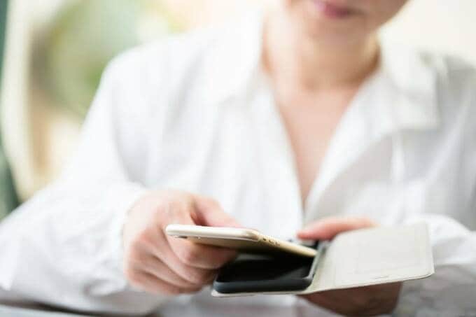 スマホをスマホケースに入れる様子