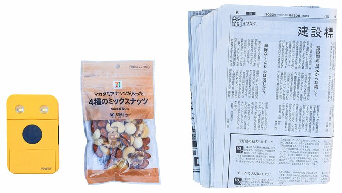 私がEDCポーチのほかに持ち歩いているもの。左から、モバイルバッテリー、おやつ兼非常食、新聞紙