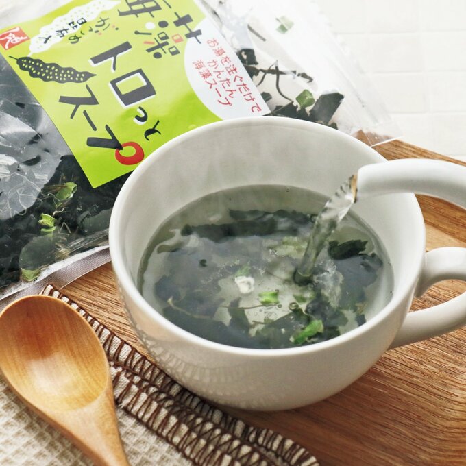 具材の入った白いカップにお湯を注ぐ様子
