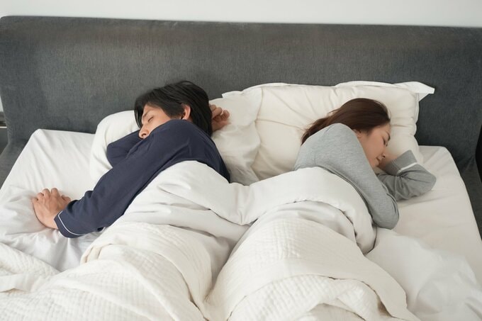 ベッドで寝る夫婦