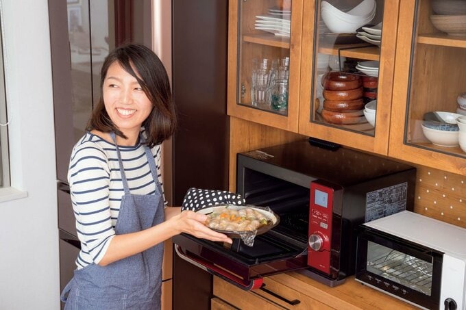 電子レンジから料理を取り出す女性