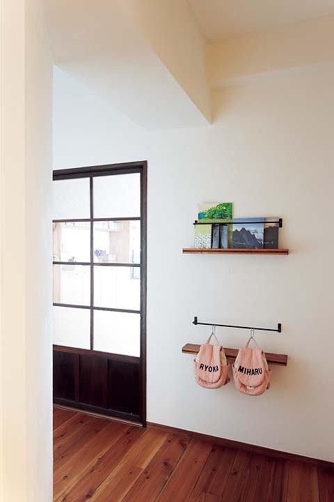 廊下にバーや棚で見せる収納を