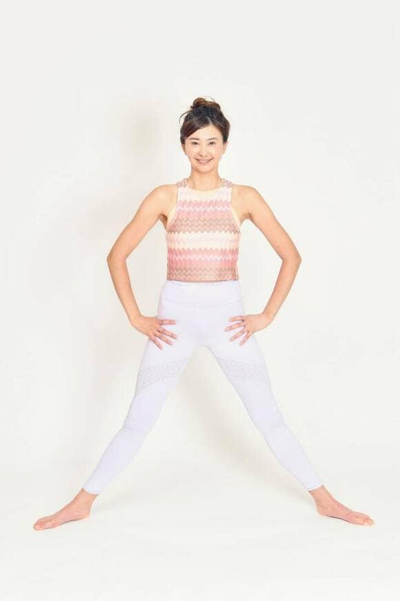 手を脚のつけ根に当て脚を大きくひらく女性