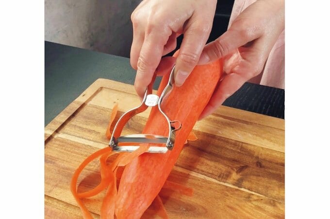 ピーラーでにんじんの皮むきをする手元