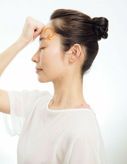 額にこぶしの平らな面を押し当てて、ほぐす