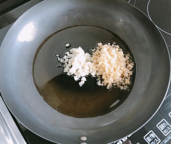 フライパンにゴマ油とニンニク、ショウガを入れて弱火にかける。