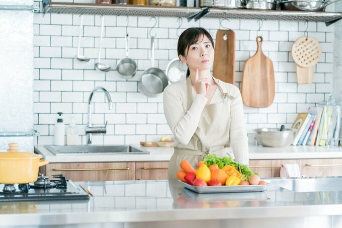 キッチンで悩む女性