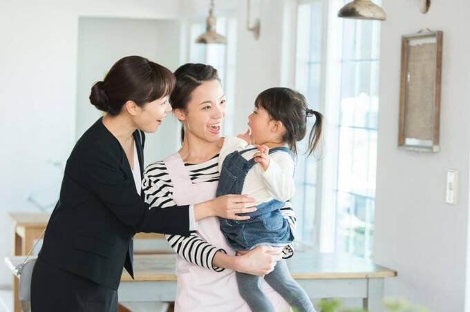 子どもを抱く女性と話しかける女性