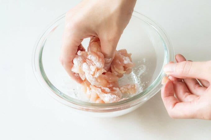 ボウルの中で片栗粉と鶏胸肉を混ぜている