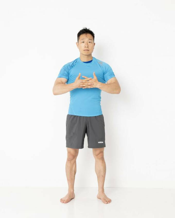 両手の指を腕の前で組み合わせる