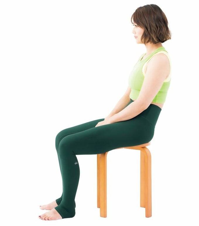 背中丸めて座る女性