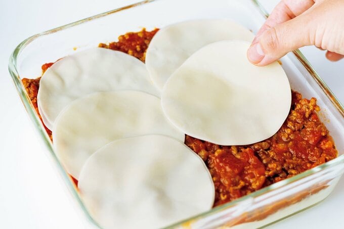 ソースの上にぎょうざの皮を並べる様子