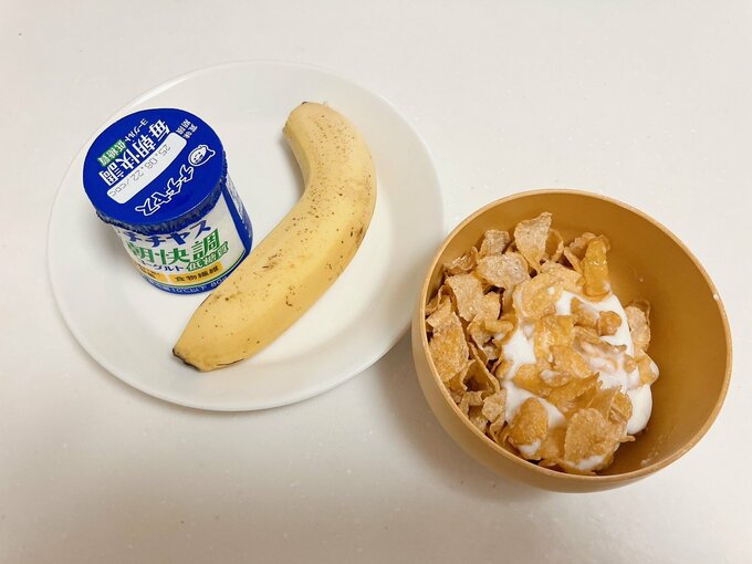 シリアルにバナナとヨーグルトをあわせた朝食の図