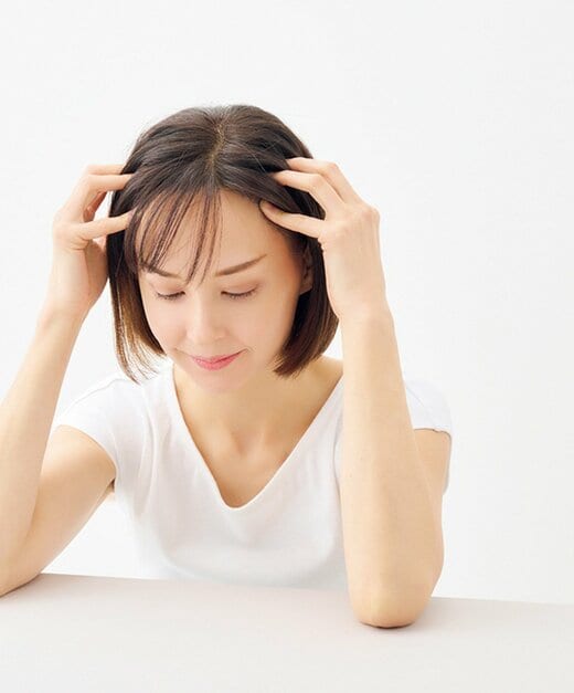 側頭部を押し上げる女性
