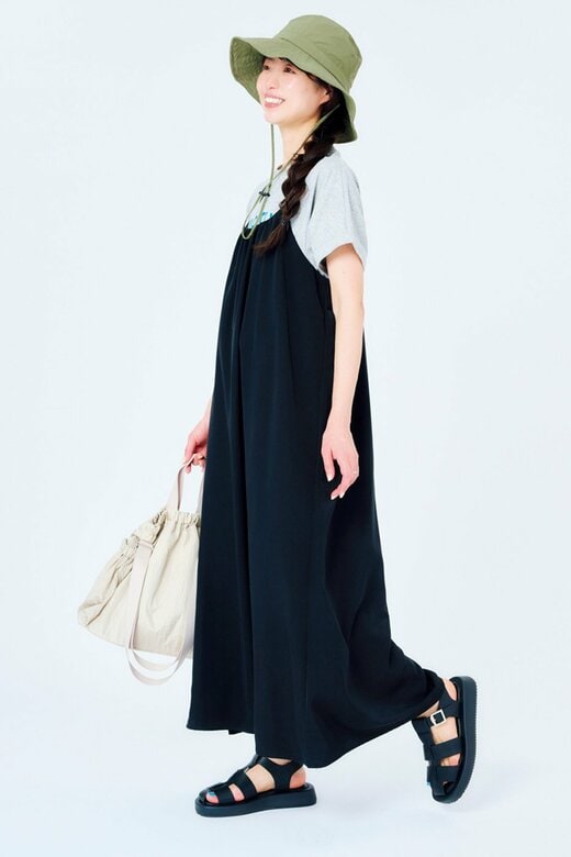 緑のつば広ハットをかぶった黒いワンピース姿の女性