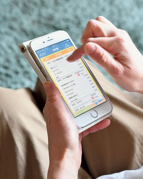 携帯アプリで日ごとに使った金額を確認する様子