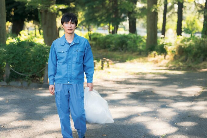 ゴミ袋を持って立つ滝沢さん