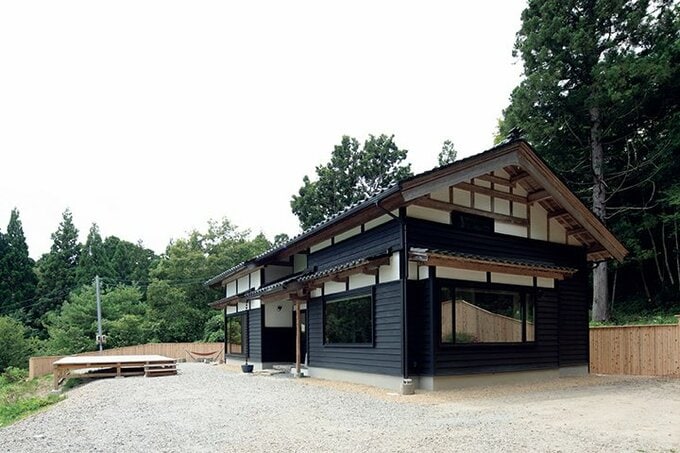 瓦葺きの屋根に、外壁は漆喰と杉下見板張りで仕上げられた古民家風の建物
