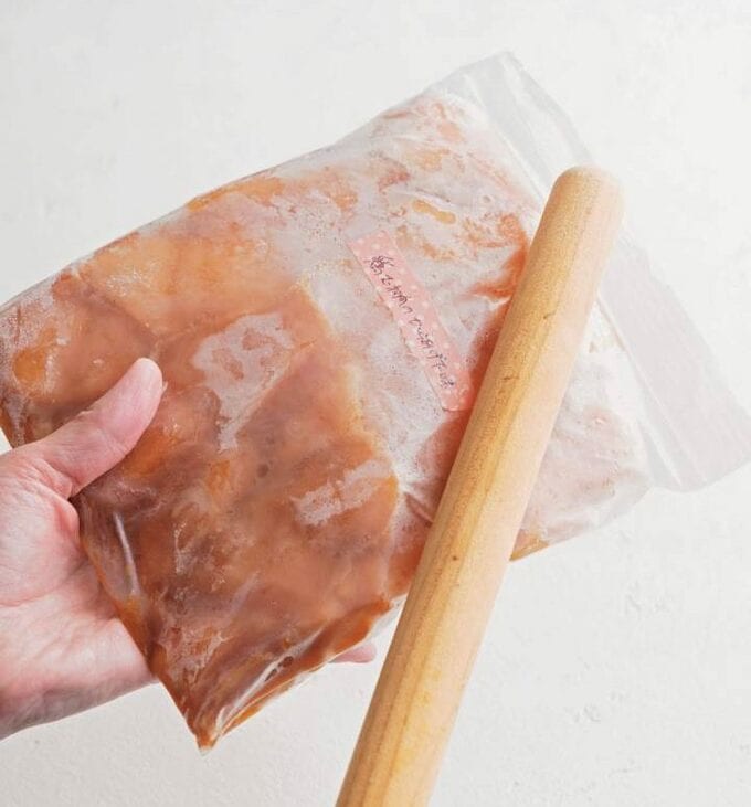 肉キットを袋ごとめん棒でたたく様子