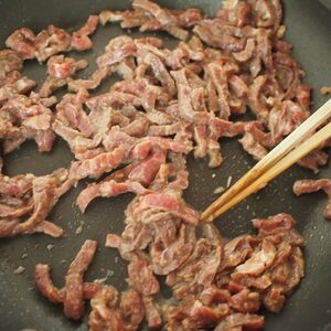 牛肉を中火で炒めて皿に取り出す