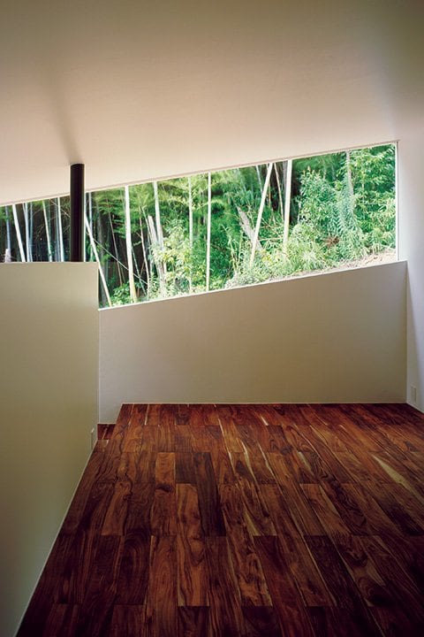 スリット状の開口から竹林を眺める