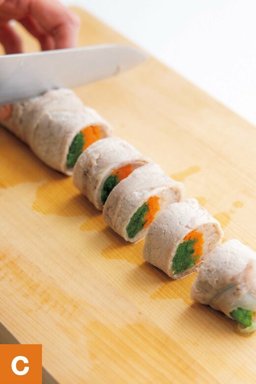 棒状の肉巻きを包丁で一口サイズに切っている