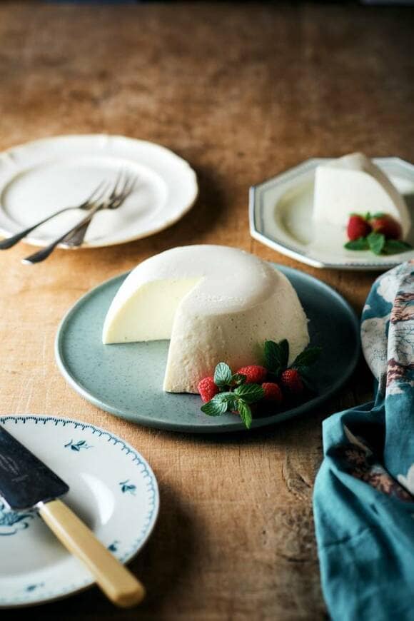 レアチーズドームケーキのまわりにお皿やフォークなど