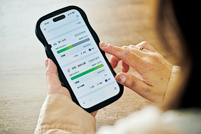 スマホで預金口座の画面を見る女性
