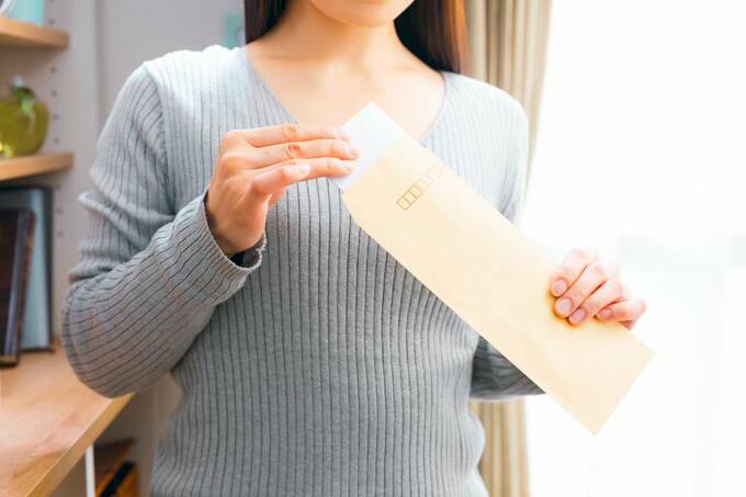 封筒を持つ女性