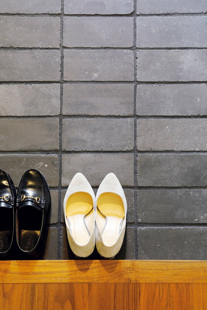 炭のようなシックな色合いのタイルで仕上げた玄関