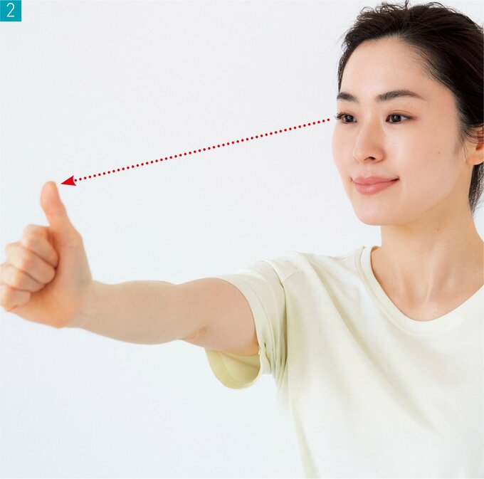 ひじを伸ばして親指を見る女性