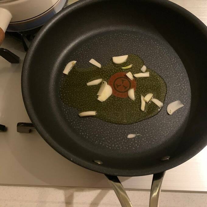 フライパンを中火にかけてオリーブオイルと細切りにしたニンニクを入れて