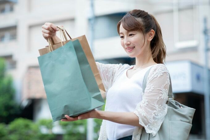 買い物袋をみてほほ笑む女性