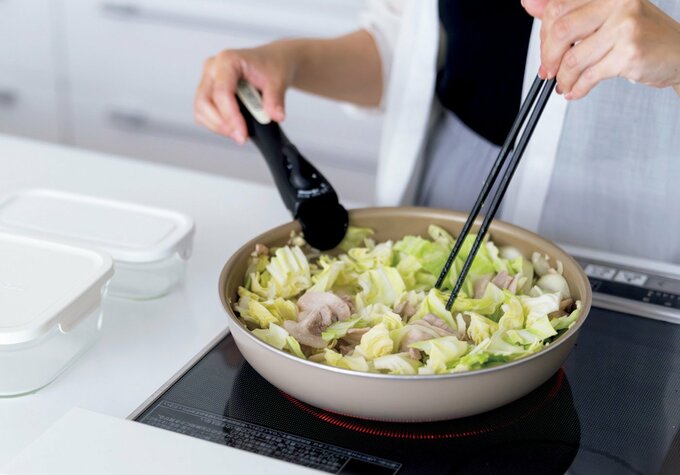 IHコンロのフライパンで豚肉とキャベツを炒めている様子