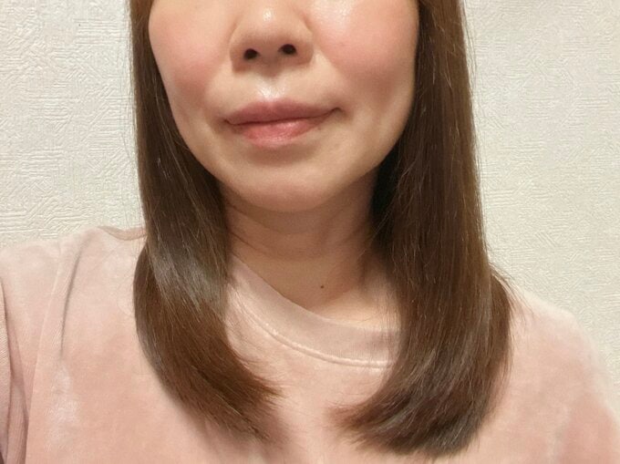鼻から胸元までの、女性の自撮り。「Gyutto」でケアされた髪の毛が写っている